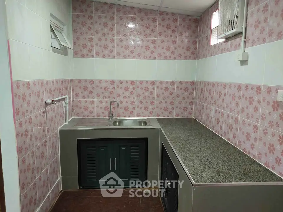 Charming kitchen with floral tile backsplash and ample counter space.