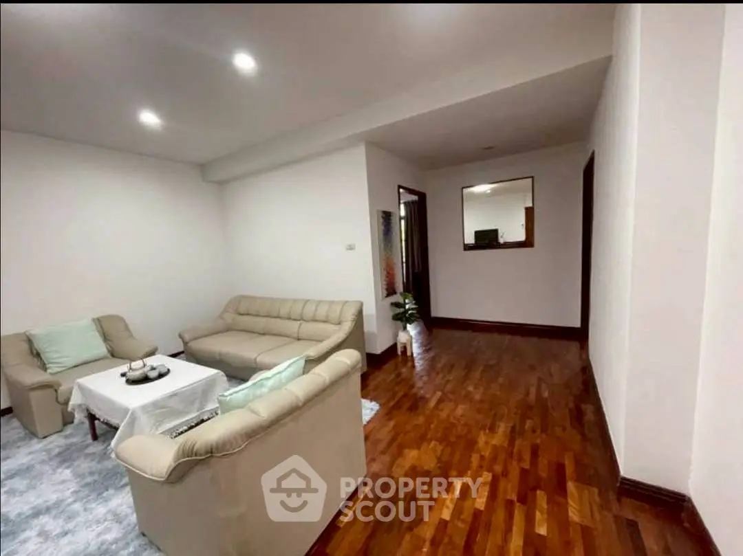 Spacious living room with elegant wooden flooring and cozy seating area.