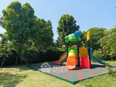 Charming outdoor playground with colorful slide set amidst lush greenery, perfect for family-friendly properties.