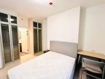 Modern bedroom with minimalist design, featuring a comfortable bed and ample closet space.