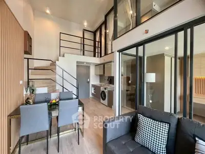 Modern duplex apartment with open living area, stylish kitchen, and elegant staircase.