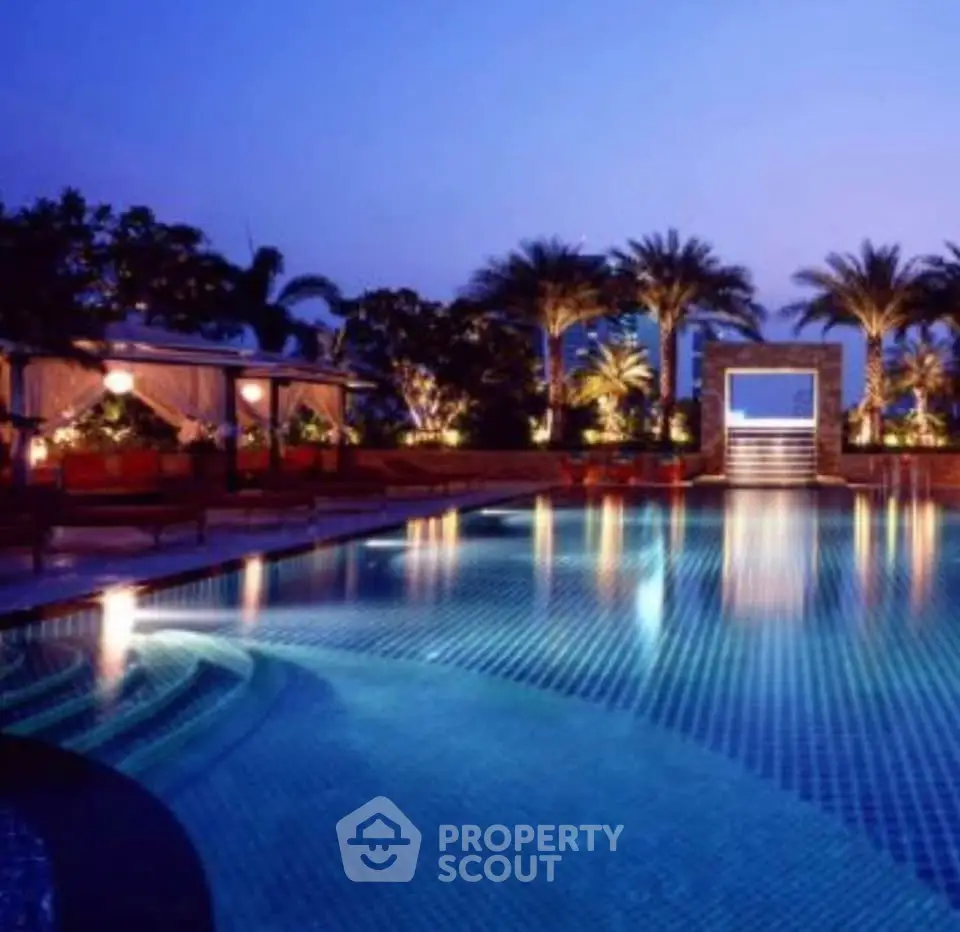 Luxurious outdoor pool area with elegant lighting and palm trees, perfect for relaxation and entertainment.