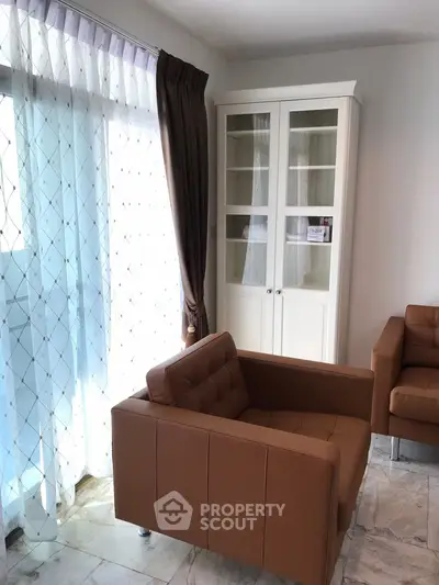 Stylish living room with modern brown armchairs and elegant glass cabinet