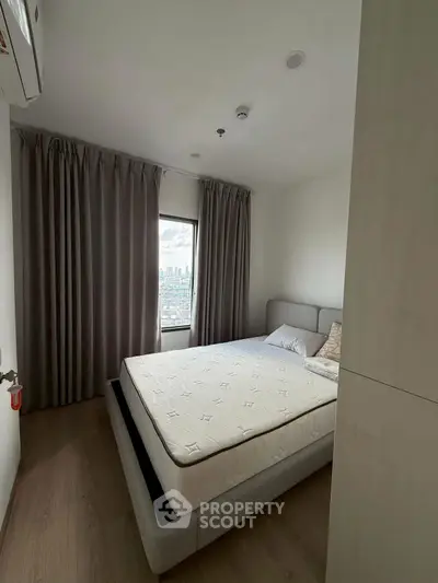 Cozy bedroom with city view, featuring a comfortable bed and modern decor, perfect for relaxation.