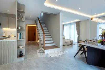 Modern open-plan living room with elegant staircase and dining area