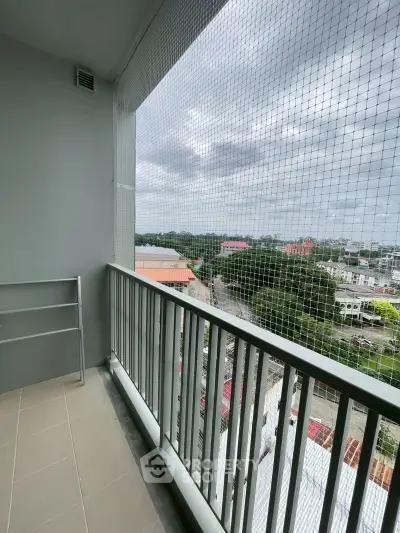 Spacious balcony with safety netting offering panoramic city views, perfect for relaxation and enjoying the skyline.