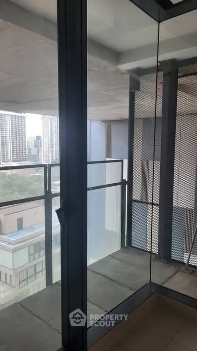Modern apartment balcony with glass railing and city view, perfect for urban living.