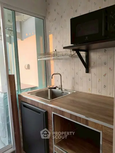 Compact kitchen with modern appliances and wooden countertop