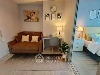 Cozy study nook with plush sofa and stylish decor adjacent to a modern bedroom.