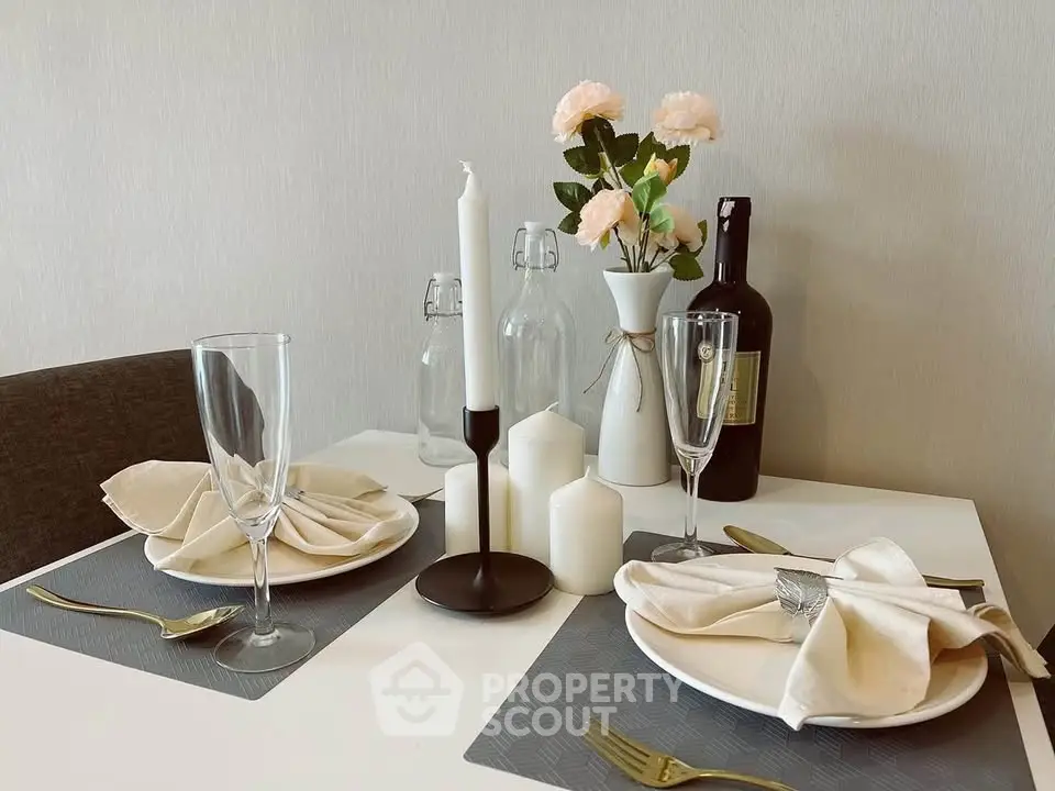 Elegant dining setup with candles and flowers on a modern table, perfect for intimate gatherings.