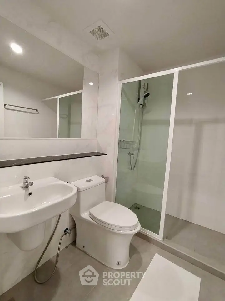 Modern bathroom with sleek fixtures and glass shower enclosure