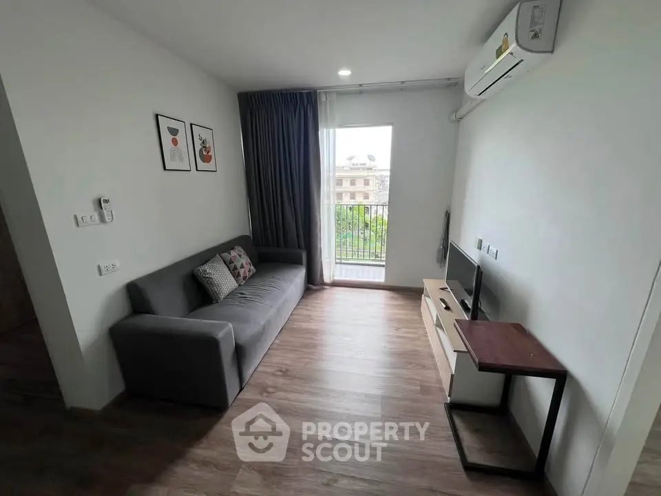 Modern living room with sleek sofa, wall-mounted TV, and balcony view in stylish apartment.
