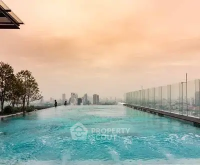 Stunning rooftop infinity pool with breathtaking city skyline views at sunset.