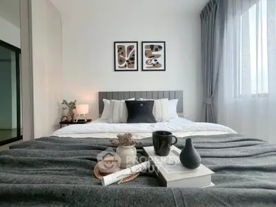 Modern bedroom with stylish decor, cozy bedding, and natural light from large window.