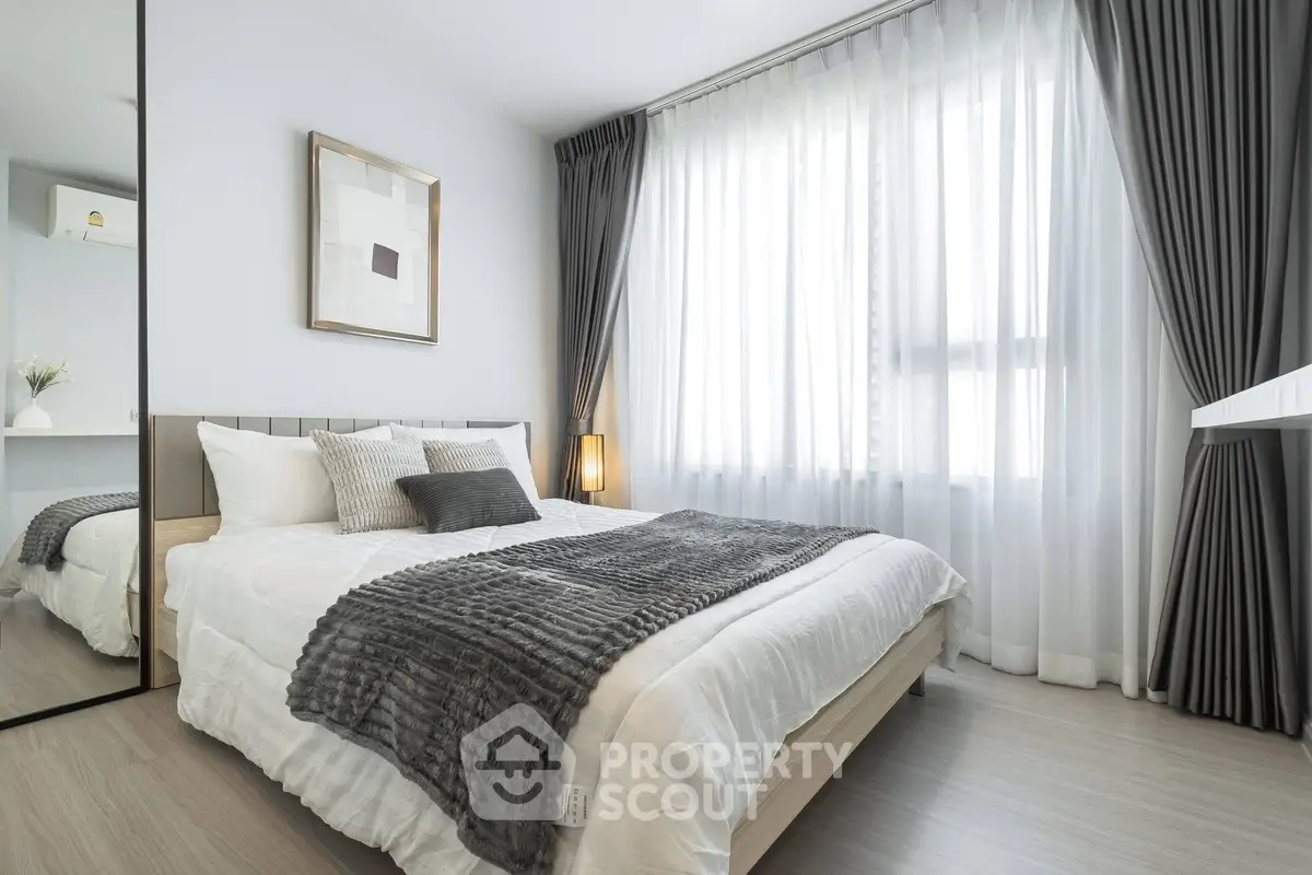 Modern bedroom with elegant decor and large window for natural light.