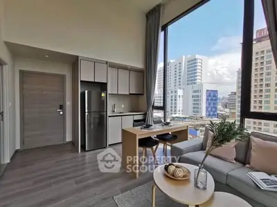 Modern open-plan living room with city view, featuring sleek kitchen and dining area.