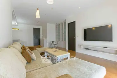 Spacious modern living room with plush sofa and wall-mounted TV