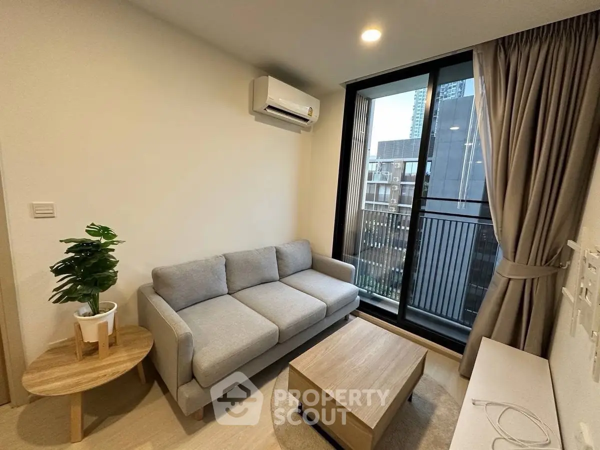 Modern living room with cozy sofa and large window offering city view