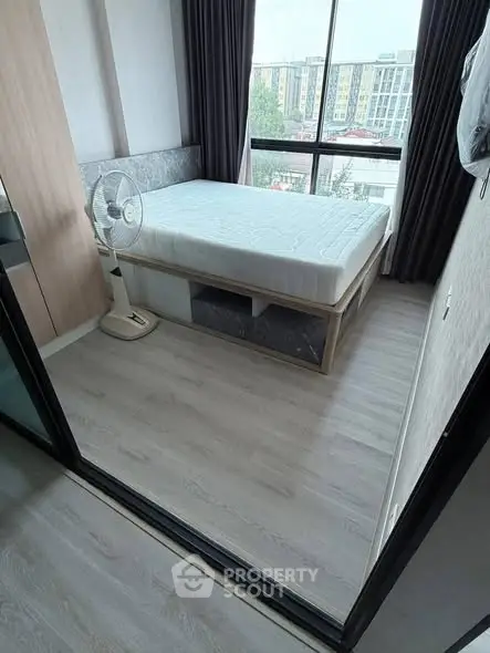 Cozy bedroom with large window and modern decor in urban apartment