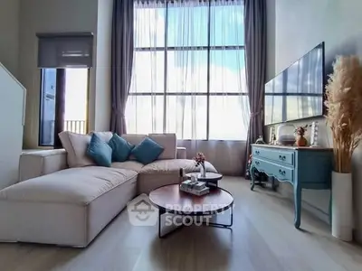 Spacious living room with large windows and stylish decor, perfect for modern living.