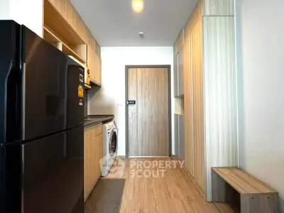 Modern kitchen with sleek appliances and wooden cabinetry in a stylish apartment.