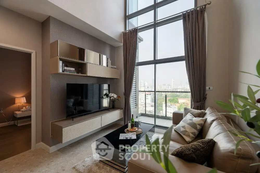Luxurious living room with floor-to-ceiling windows and modern decor in a high-rise apartment.