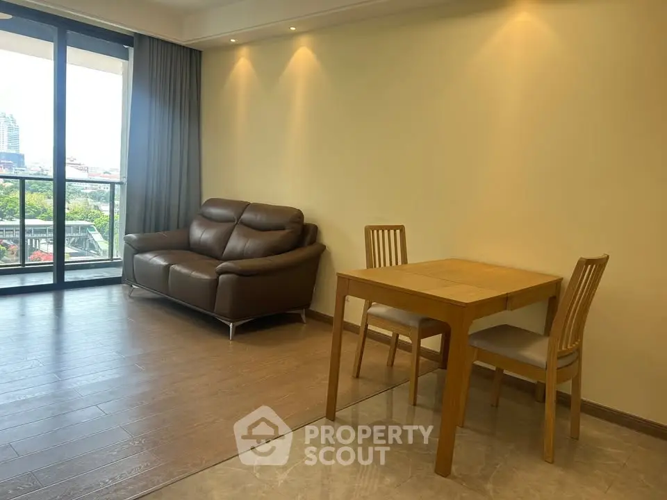 Spacious living room with modern furniture and large windows offering a city view.