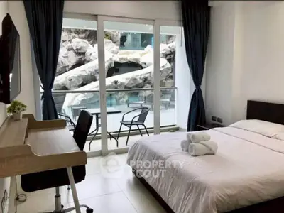 Modern bedroom with pool view, featuring a cozy bed and stylish desk, perfect for relaxation and work.