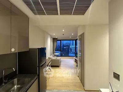 Modern open-layout apartment with sleek kitchen and spacious living area leading to a balcony.