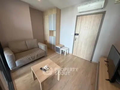Modern living room with cozy sofa, wooden flooring, and air conditioning in a stylish apartment.