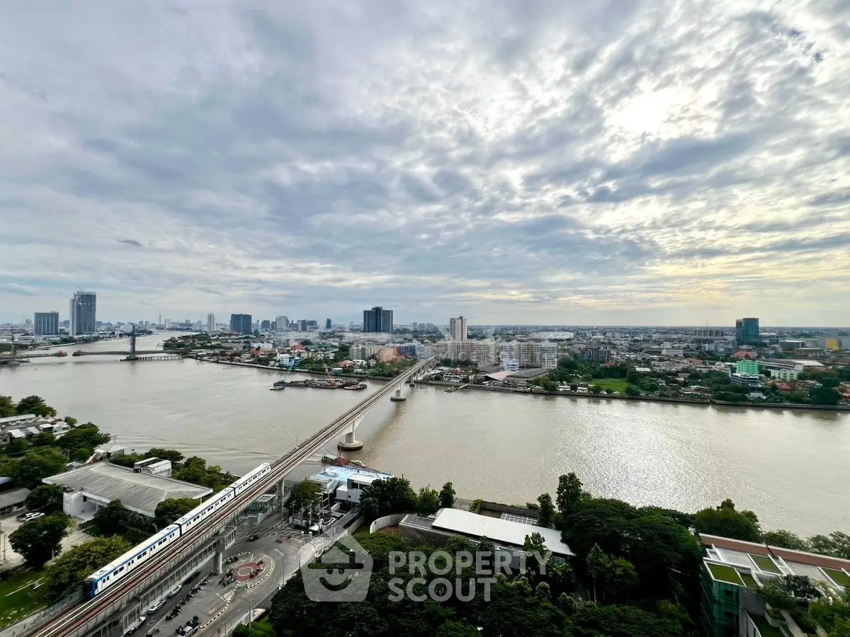 Stunning river view from high-rise building with city skyline and lush greenery.