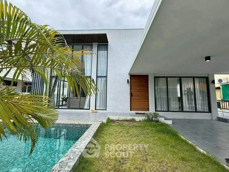 Modern luxury home with pool and garden, featuring sleek architecture and expansive windows.