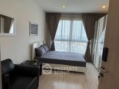 Modern bedroom with large windows and stylish decor in a high-rise apartment.