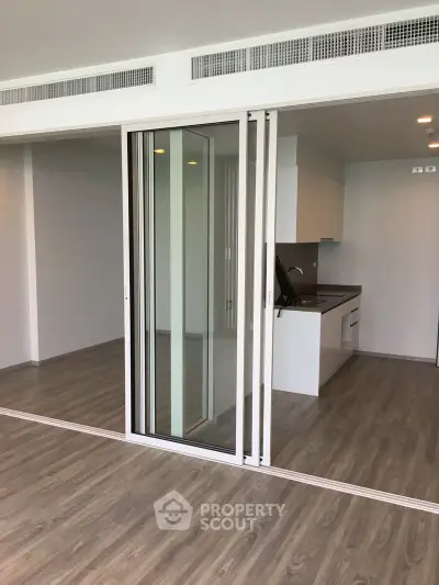 Modern open-plan kitchen with sliding glass doors and sleek flooring