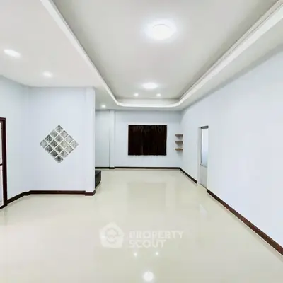 Spacious empty living room with modern lighting and tiled flooring