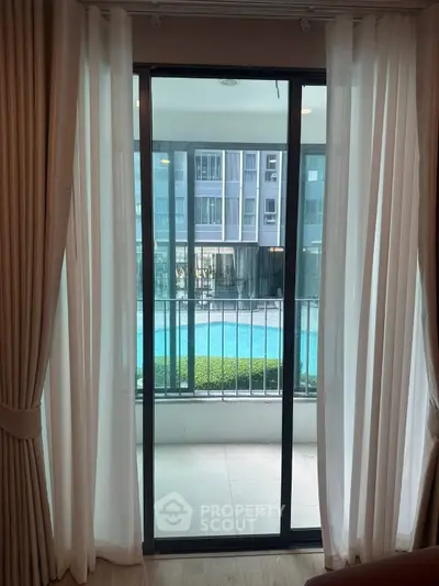 Spacious balcony with pool view in modern apartment complex