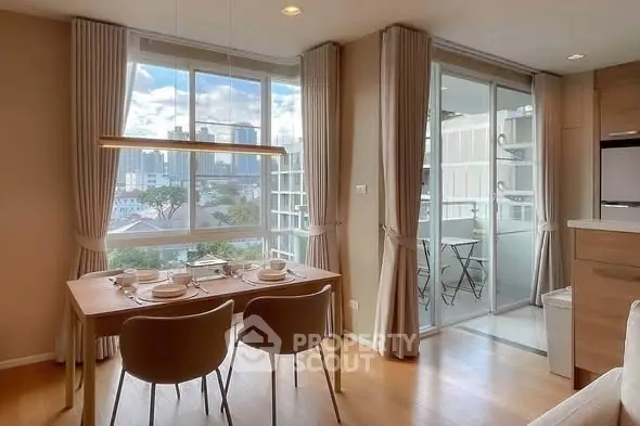 Modern dining area with large windows and balcony access in a stylish apartment.
