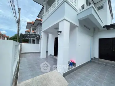 Spacious modern house exterior with tiled patio and elegant white facade