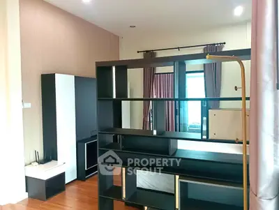 Modern living room with stylish shelving and hardwood floors in a contemporary apartment.