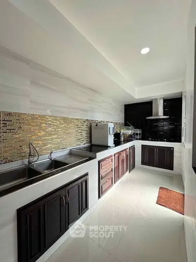 Modern kitchen with sleek cabinetry and stylish backsplash in a bright, spacious layout.