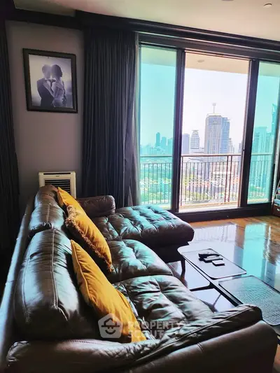 Luxurious living room with leather sofa and stunning city view through large windows.