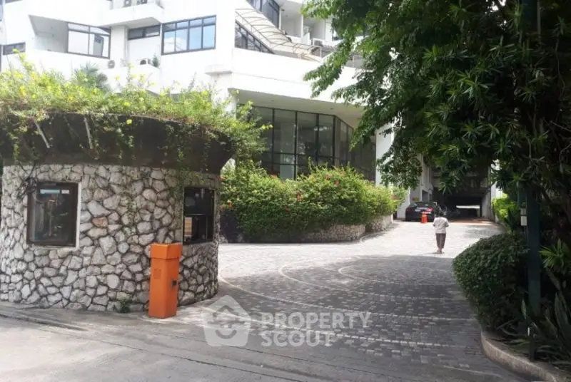 Elegant residential entrance with lush greenery and modern architecture