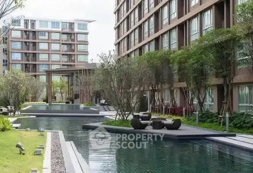 Luxurious apartment complex with serene pool and lush garden landscaping.
