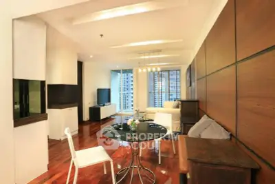Modern living room with wooden accents and city view, featuring sleek furniture and ambient lighting.