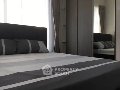 Modern bedroom with stylish decor and ample natural light, featuring a comfortable bed and sleek wardrobe.