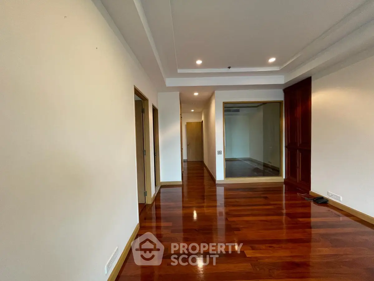 Spacious interior with polished wooden floors and modern recessed lighting.
