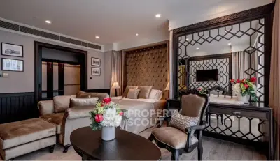Luxurious bedroom with elegant decor and plush seating in a modern apartment.