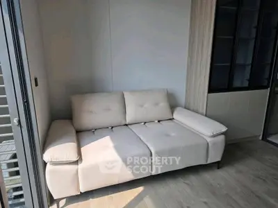 Modern living room with stylish beige sofa and sleek wooden flooring, perfect for cozy relaxation.