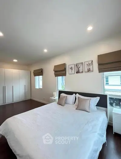 Spacious bedroom with elegant decor and ample natural light in modern home.