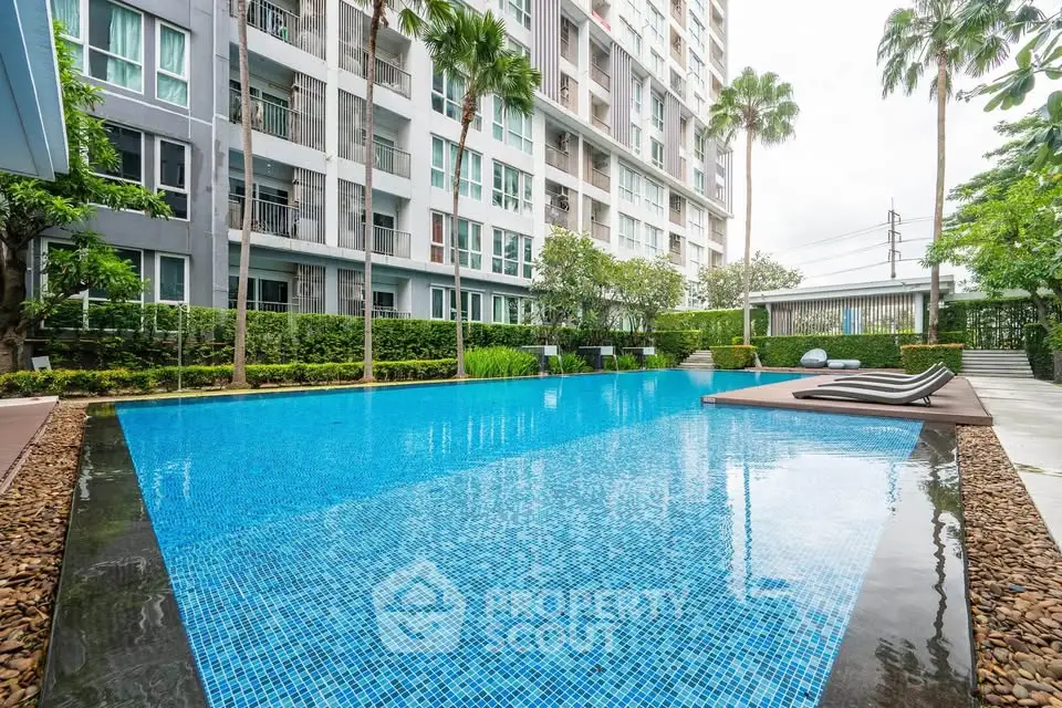 Luxurious apartment complex with a stunning outdoor pool and lush greenery.